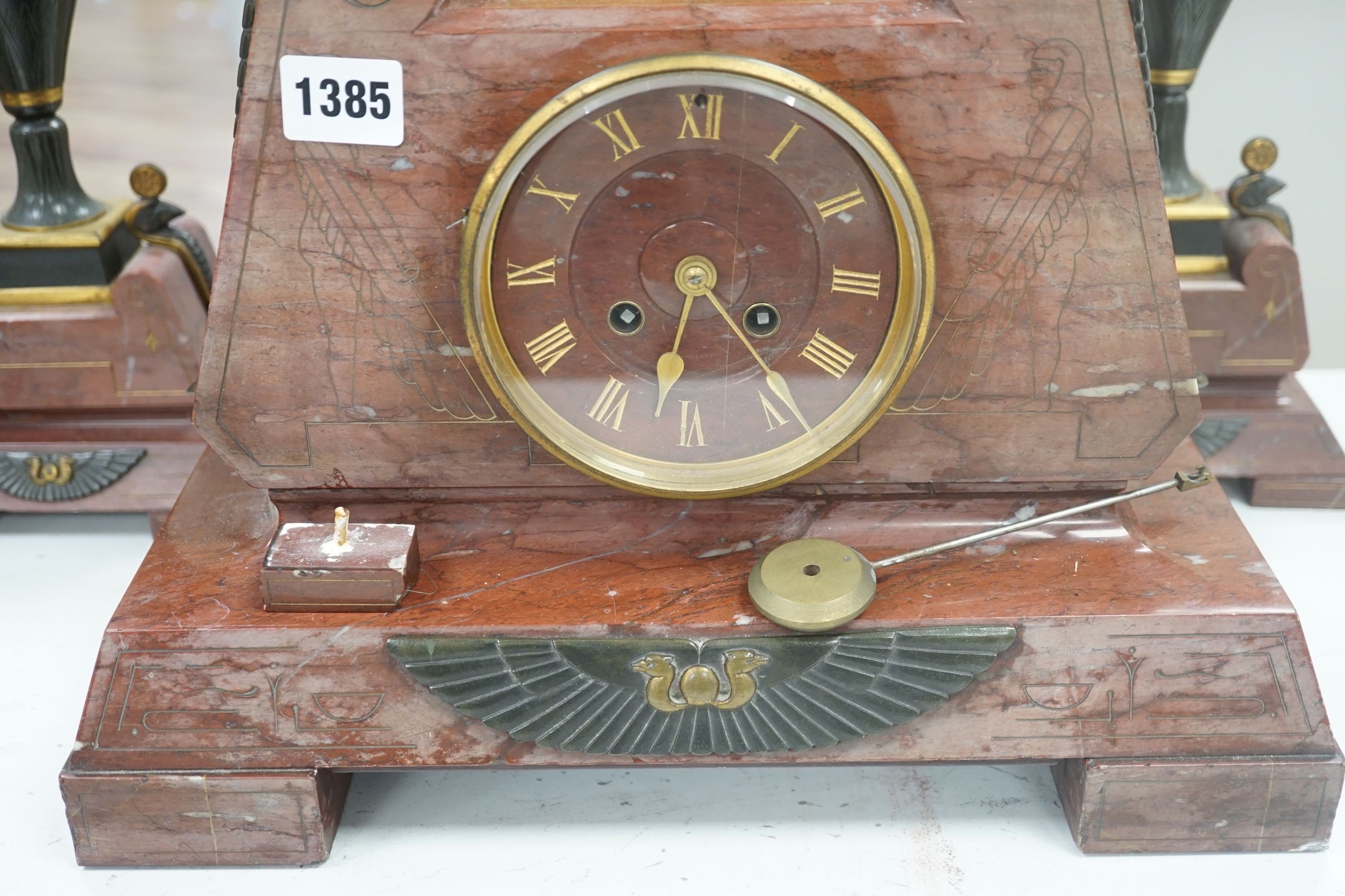 A late 19th century French Egyptian Revival gilt bronze and rouge marble clock garniture, 51cm